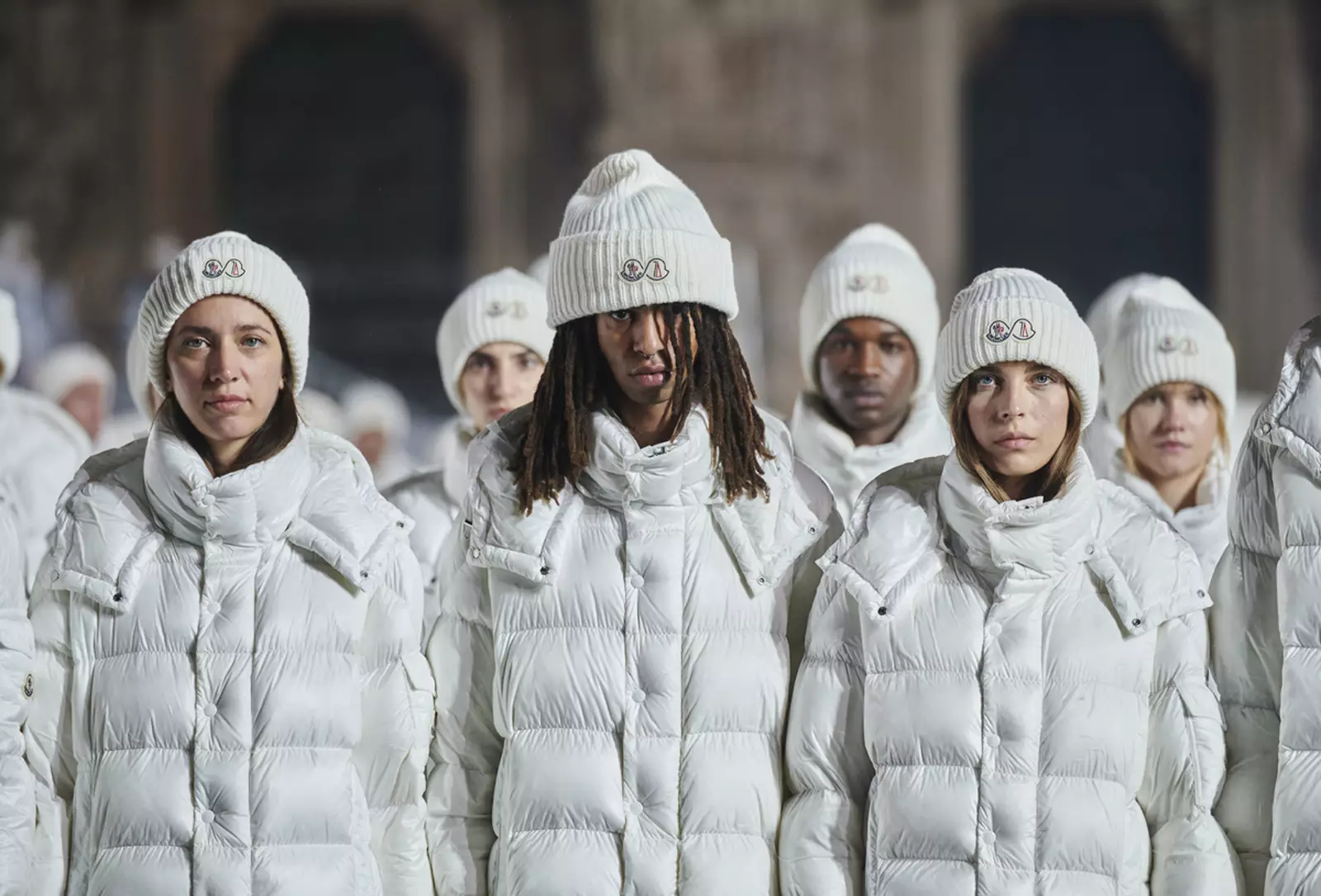 Models lined up for in white puffer jackets and hats for Moncler's 70th anniversary