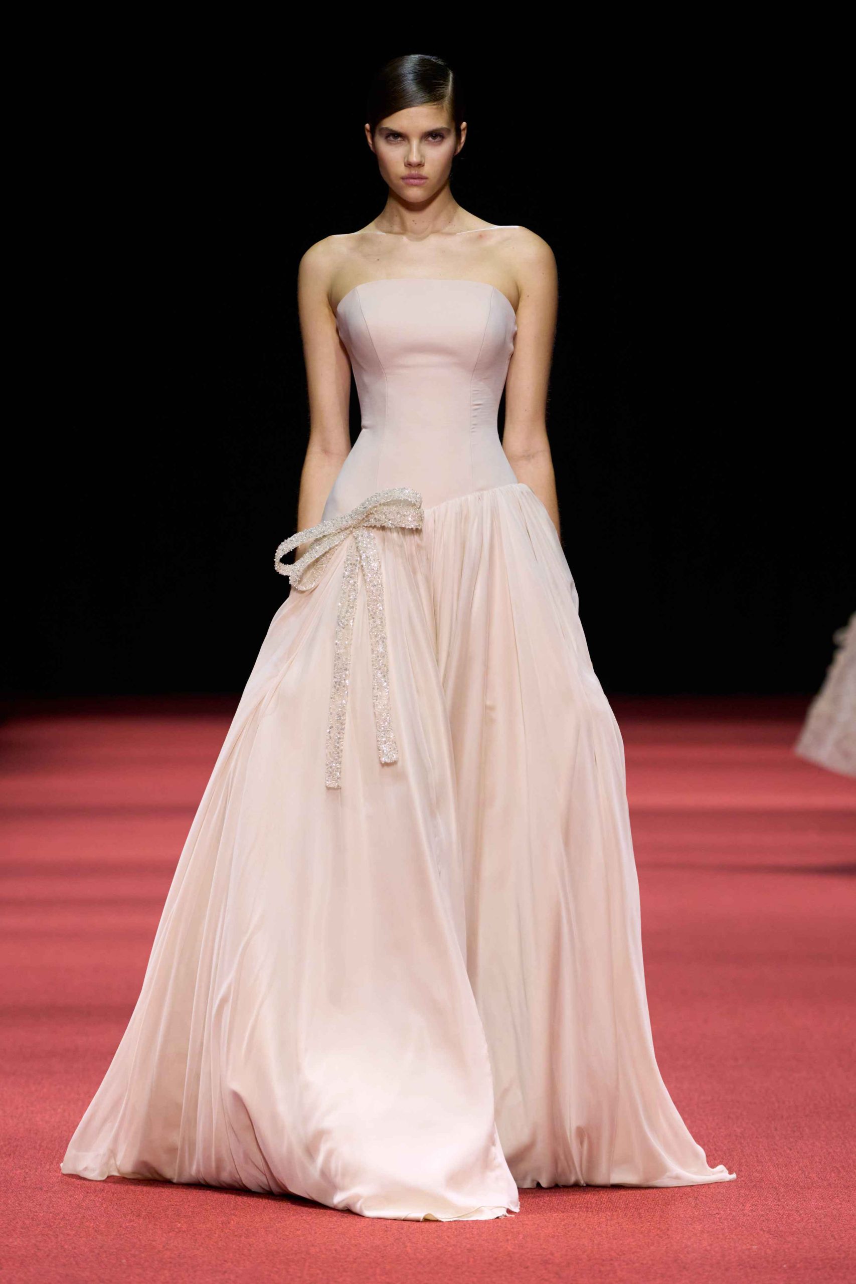 Model in a pale blush strapless gown with a full tulle skirt at the GNL Couture SS27 show
